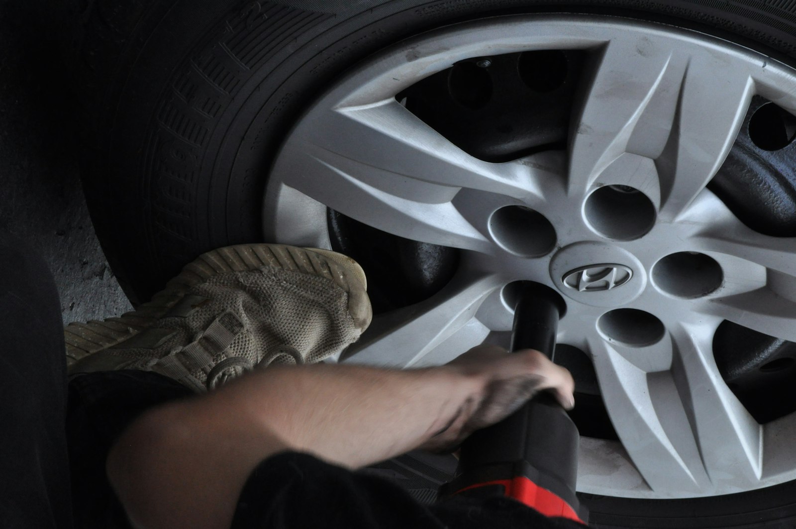 Mecánico usando una llave de impacto en la rueda de un auto