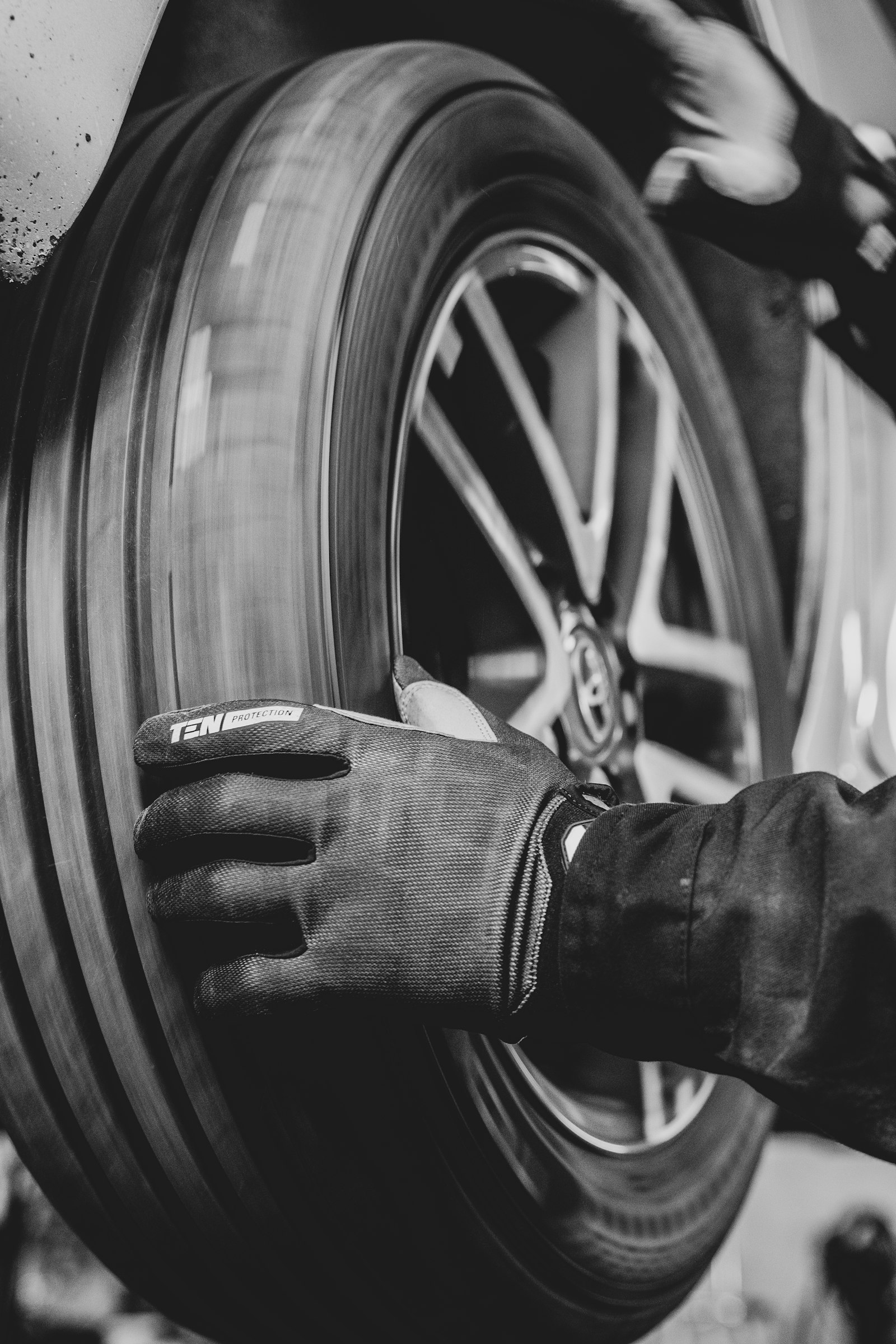 Persona con guantes trabajando en la llanta de un auto